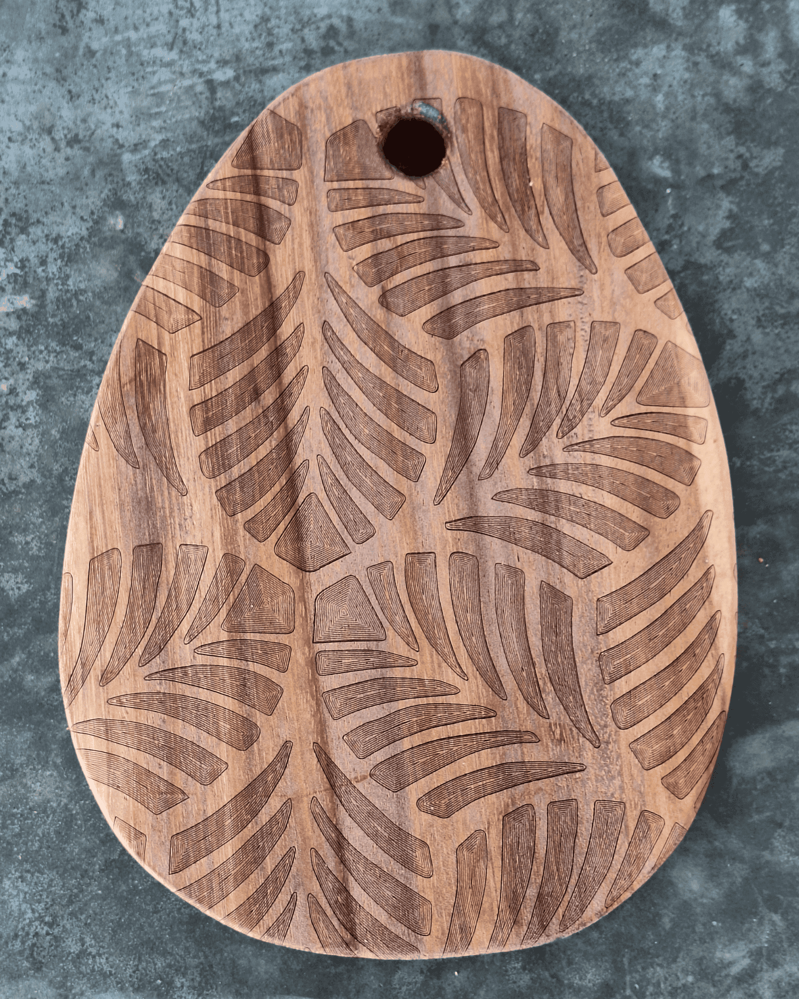 Tiny egg shaped cutting board with tropical leaves engraved