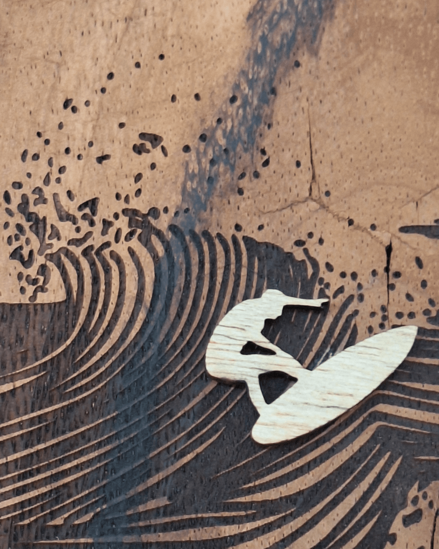 detail of the laser engraving and the wooden surfer